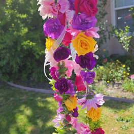 Colorful flower lei with roses and daisies hanging outdoors