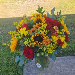 Bouquet of red roses and sunflowers in a glass vase