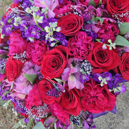 Bouquet of red and pink roses with purple flowers and butterfly accents