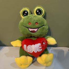 Plush green frog holding a red heart with the word LOVE