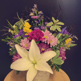 Mixed bouquet with a large white lily in a metal container