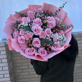 Large bouquet of pink roses and carnations wrapped in pink paper
