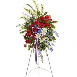 Standing floral spray with red, white, and blue flowers on an easel