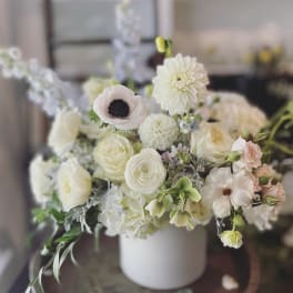 White and blush floral arrangement in a white vase