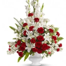 Red roses and white lilies in a white pedestal vase