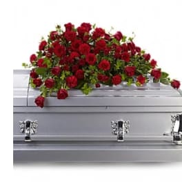 Red rose casket spray on a silver casket