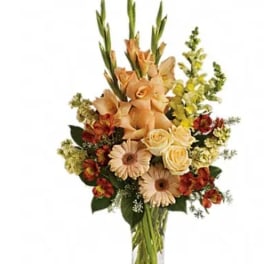 Tall mixed flower arrangement in a clear glass vase