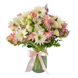 Pink and white mixed bouquet in a glass vase with a pink ribbon