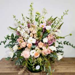 Large pastel floral arrangement in a dark vase