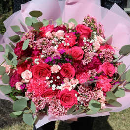 Large bouquet of pink and red roses with eucalyptus in pink wrap