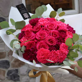 Bouquet of hot pink roses and carnations with eucalyptus in white wrap