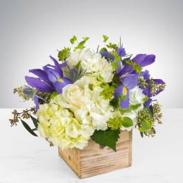 Purple and white floral arrangement in a wooden box