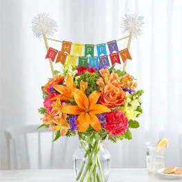 Birthday bouquet in a glass vase with a colorful banner topper