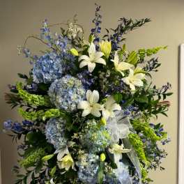 Tall standing floral spray with blue hydrangeas and white lilies