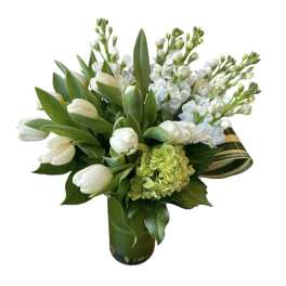 White tulips and stock in a green glass vase