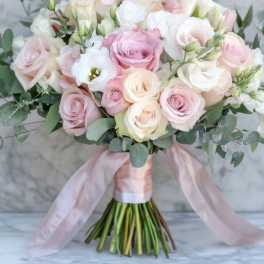 Bouquet of pale pink and white roses with eucalyptus and a pink ribbon