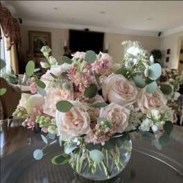 Blush roses and pink flowers in a clear glass vase