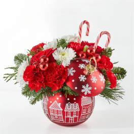 Red and white holiday arrangement in a decorated red ornament vase