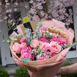 Pink rose bouquet wrapped in blush paper with eucalyptus accents