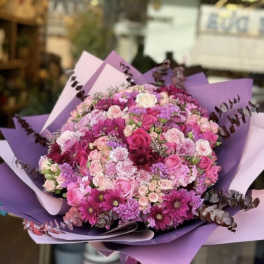 Large bouquet of pink and purple flowers wrapped in lavender paper