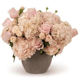 Blush pink roses and hydrangeas arranged in a gray vase