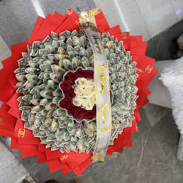 Bouquet of red and white roses wrapped with dollar bills and red paper