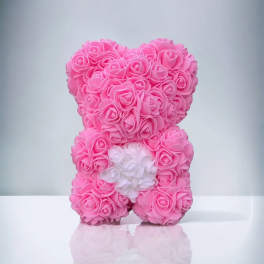 Pink teddy bear made of roses with a white flower accent