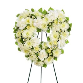 White floral heart-shaped wreath on a stand