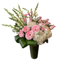Tall pink and white flower arrangement with gerbera daisies and hydrangeas in a green-wrapped vase
