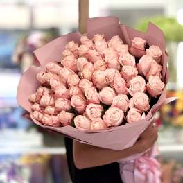 Large bouquet of pale pink roses wrapped in pink paper