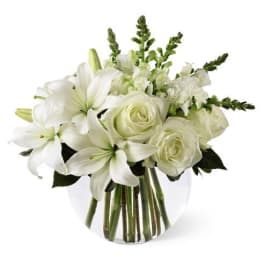 White lilies and roses arranged in a clear glass vase