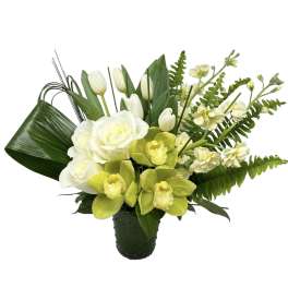 White roses, tulips, and green orchids in a dark vase