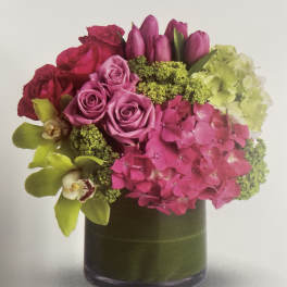 Pink and purple floral arrangement in a dark glass vase