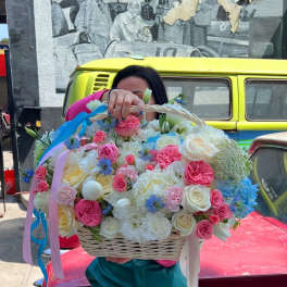 Large basket of pink, white, and blue flowers with ribbon streamers