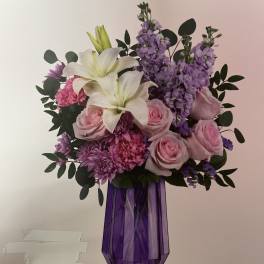 Pink and purple bouquet with white lilies in a purple vase