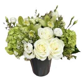 White roses and green orchids in a dark vase