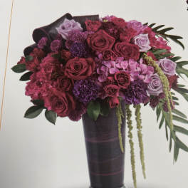 Bouquet of pink and purple roses in a tall dark vase