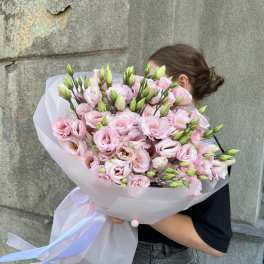 Large bouquet of pale pink lisianthus wrapped in white paper with ribbon