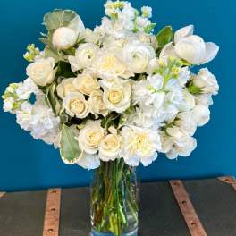 White roses and ranunculus in a clear glass vase