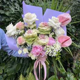Bouquet of pink and white flowers wrapped in lavender paper