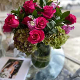Pink roses and hydrangeas arranged in a glass vase
