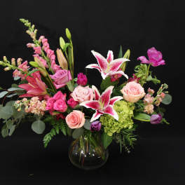 Pink and white mixed flower arrangement in a glass vase
