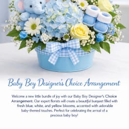 Blue and yellow baby-themed flower arrangement with a teddy bear and booties