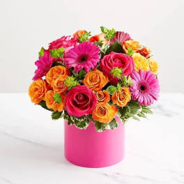 Bouquet of pink and orange roses with pink gerbera daisies in a pink vase