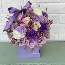 Lavender and purple rose bouquet in a purple box with ribbon