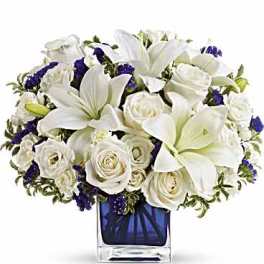 White lilies and roses in a blue glass vase