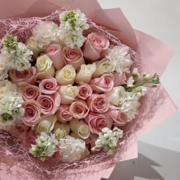 Bouquet of pink and white roses wrapped in pink paper