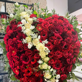Heart-shaped bouquet of red and white roses with red daisies