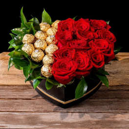 Red roses and gold-wrapped chocolates in a heart-shaped box