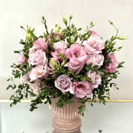 Pink roses and lisianthus in a pink glass vase